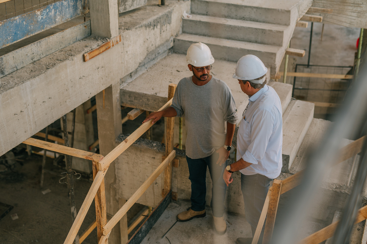 Acompanhamento de obra Empominas, com dois responsáveis técnicos conversando em um dos andares sob construção.